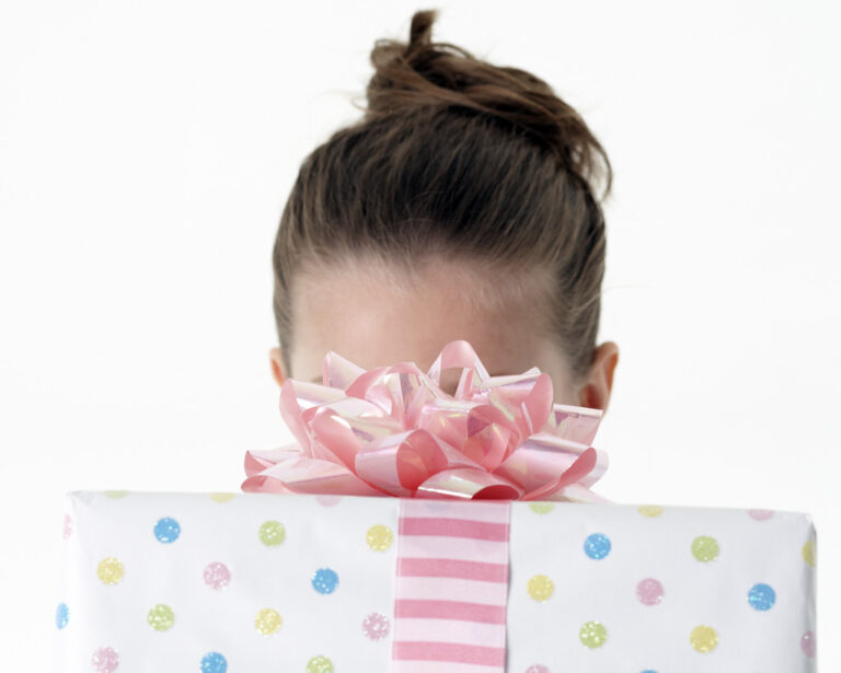 Girl holding up colorful birthday present