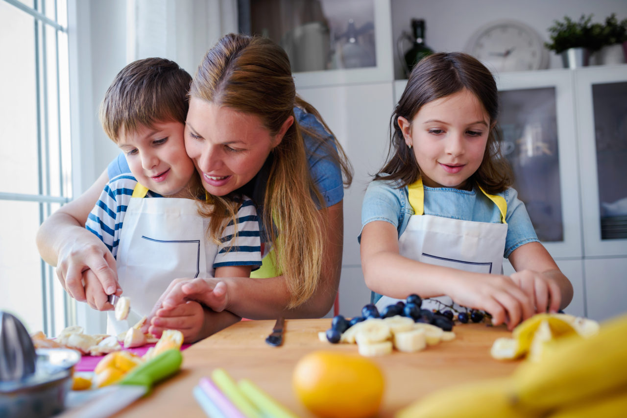 Be a better mom to young children - Mom cooking with kids in kitchen