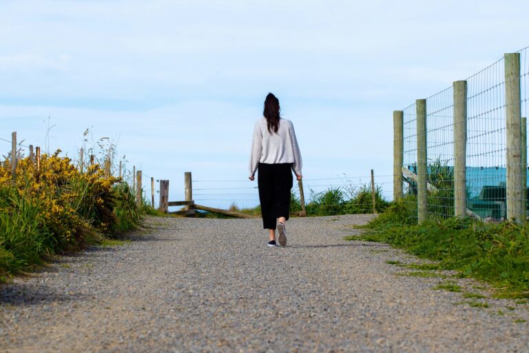 Woman walking on trail with blue skies