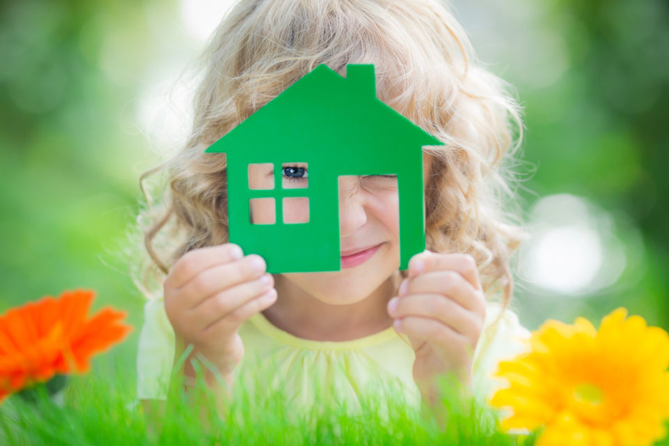 family things to Do in April - Child holding up a green cut out of a home
