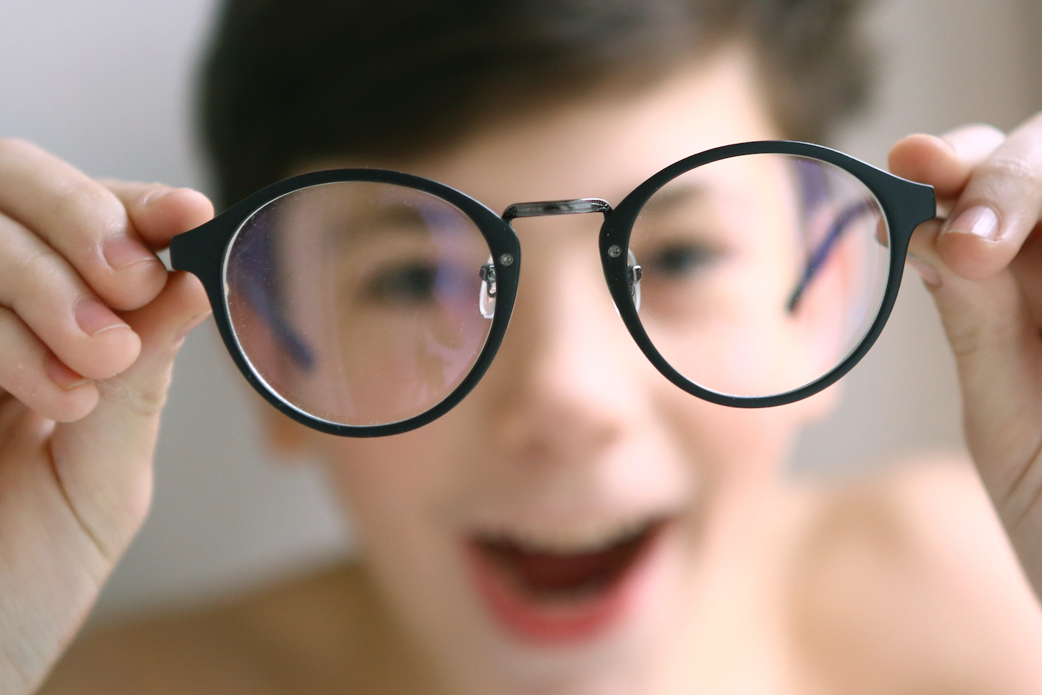 boy peering through glasses