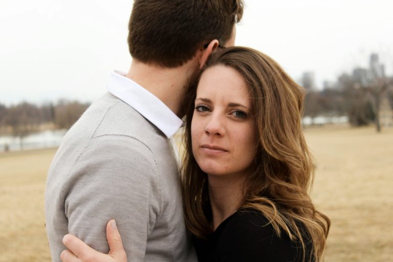 Woman looking over husband's shoulder being a martyr mom