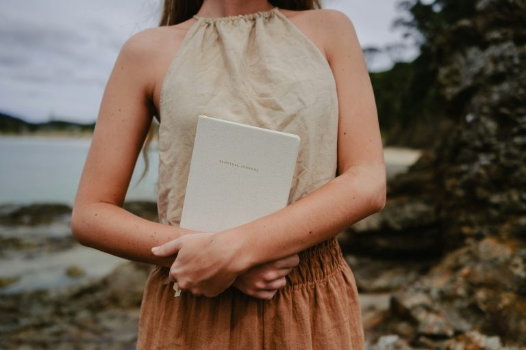 Woman in dress holding spiritual journal who wants to know God's will