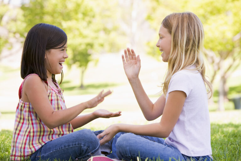 Girls playing pattycake smiling and showing kindness