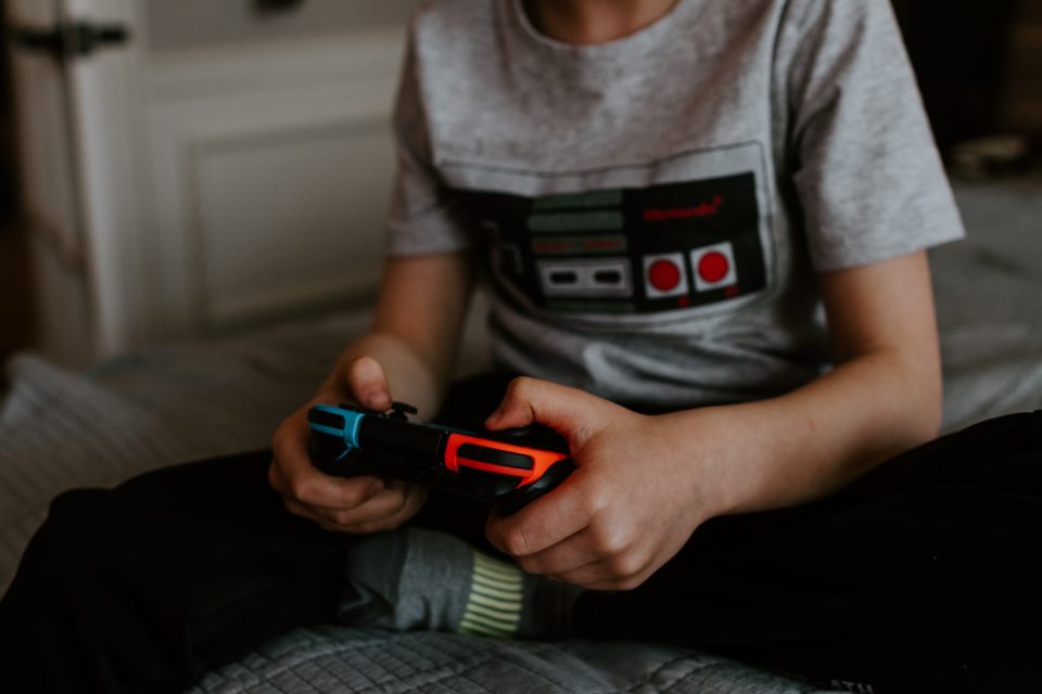 Boy holding a Nintendo controller playing video game