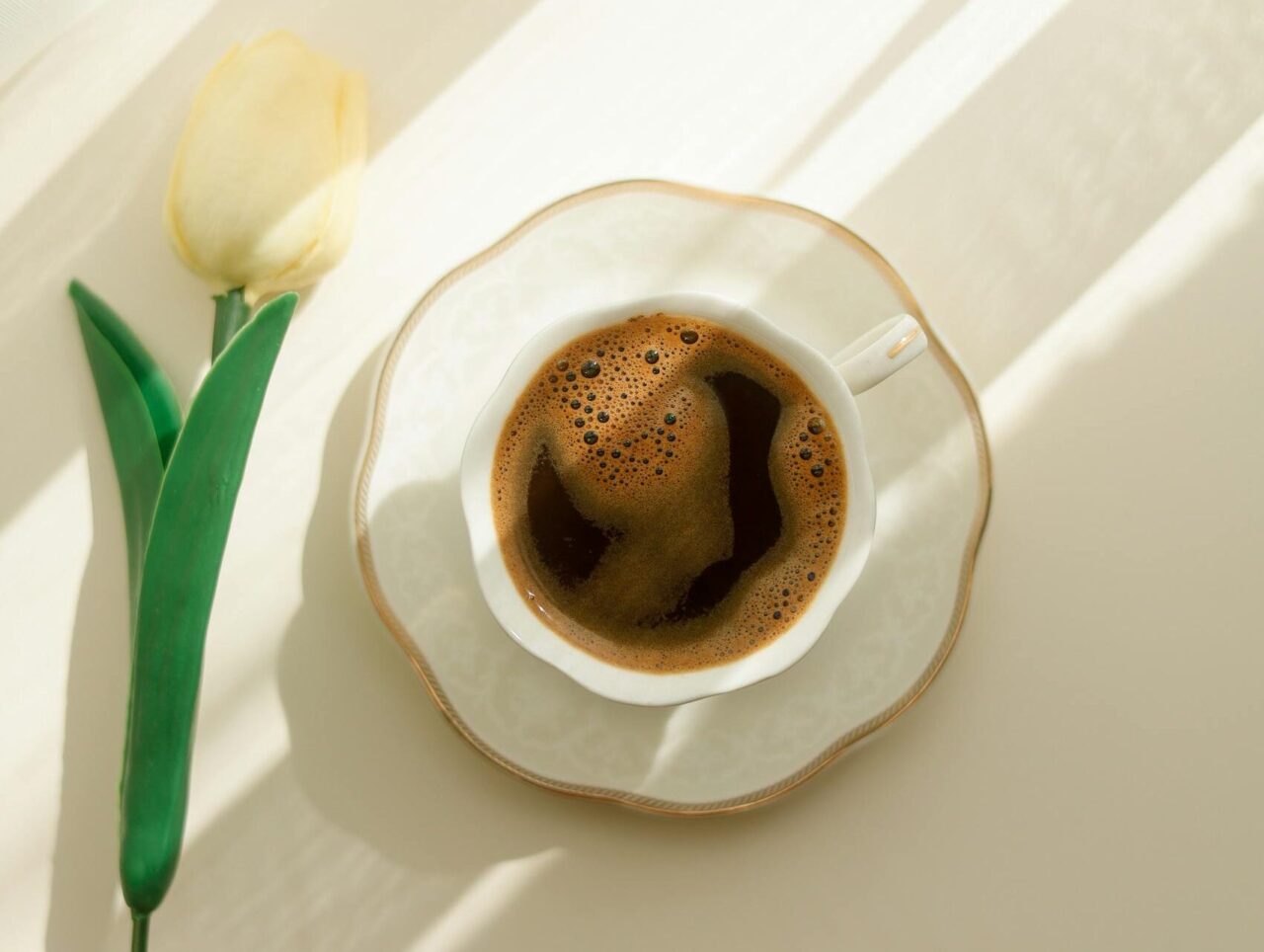 Elegant Coffee Cup with Yellow Tulip on Table