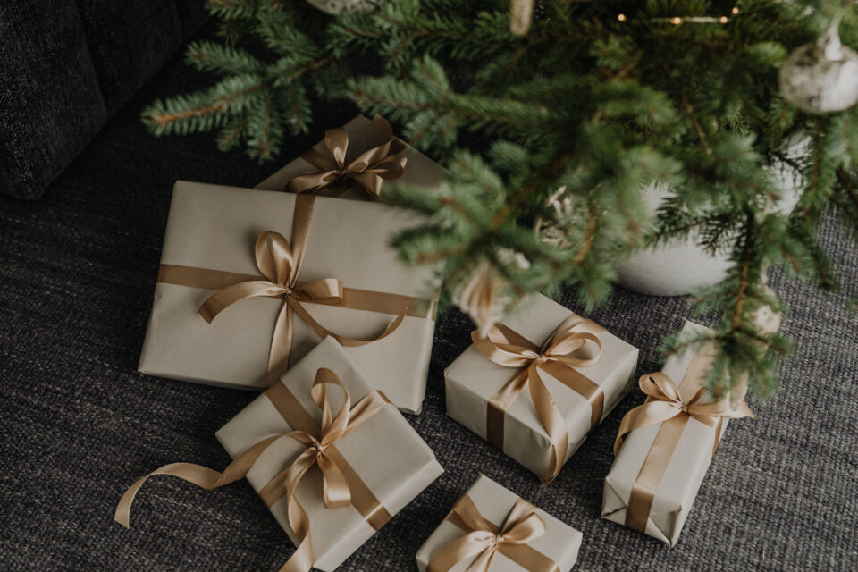 Brown gifts under Christmas tree with gold ribbon