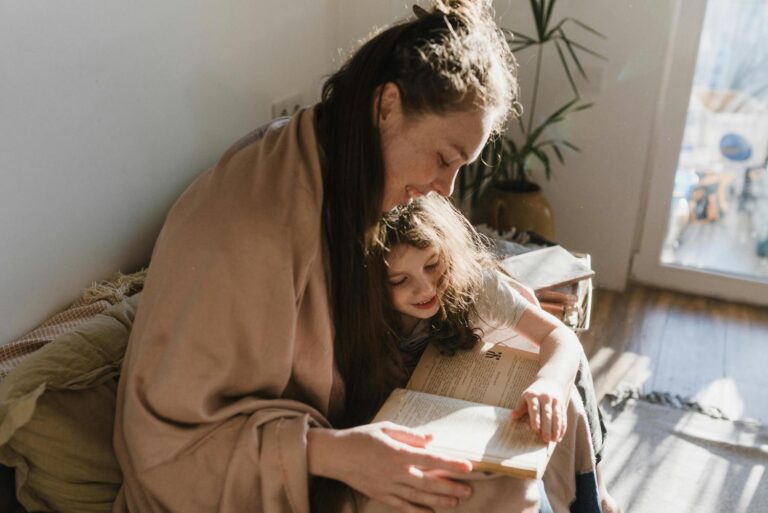 Mom reading to daughter under blanket discipling kids