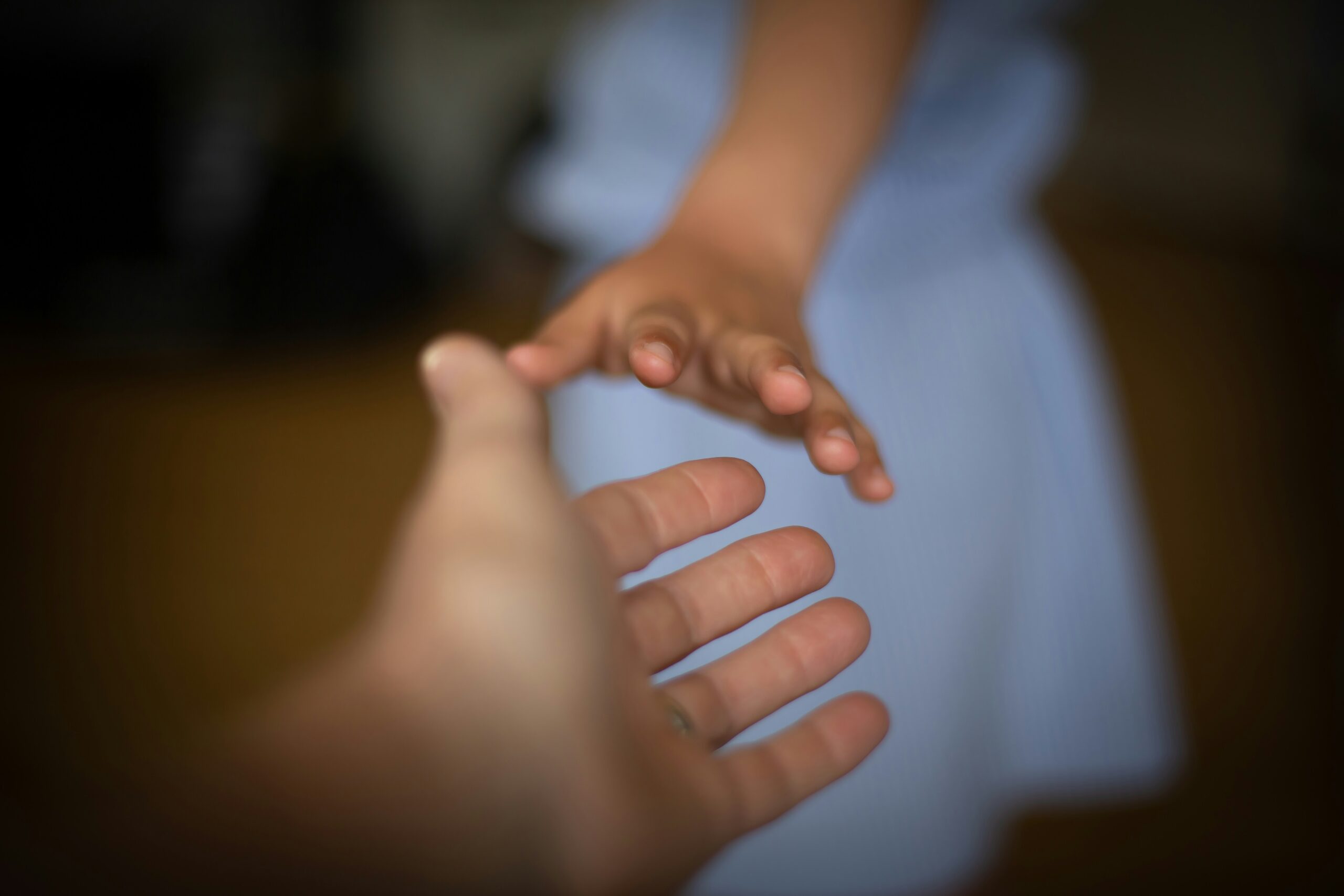 girl reaching for her father's hand on father's day