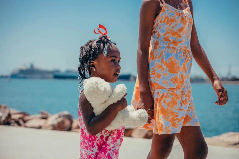 Mom and daughter walking on the beach having a meaningful summer