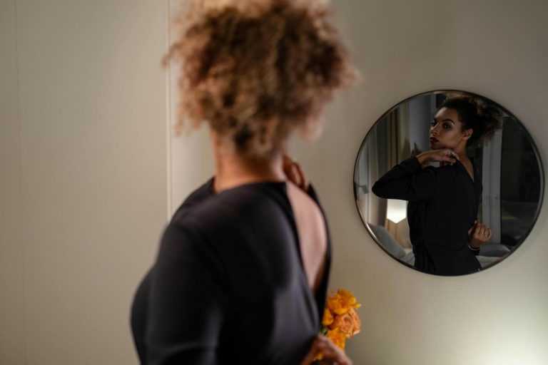 16 Bible Verses on Body Image - Woman zipping up dress looking in mirror