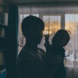 Feeling stuck as a mom: Shadow of mom with her baby by window