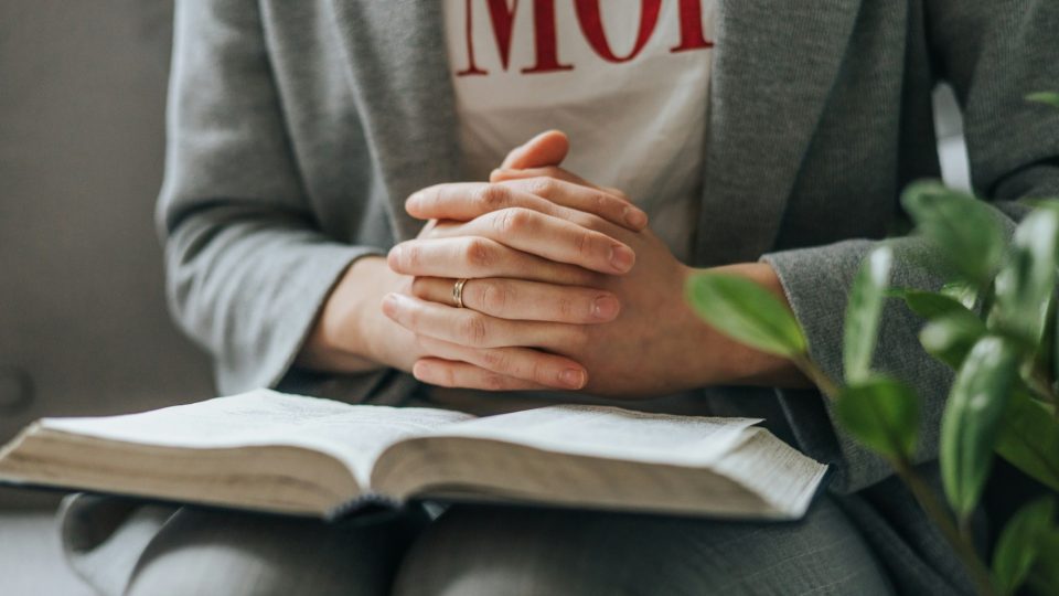 Scriptures on parenting for hard parenting days - Mom praying over bible