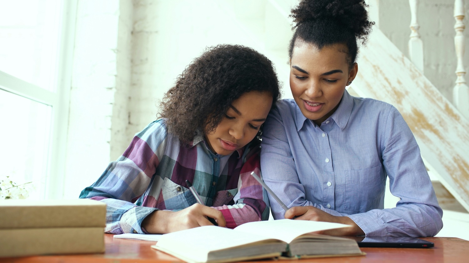 Mom and daughter doing homework at table - Balancing homeschool and work